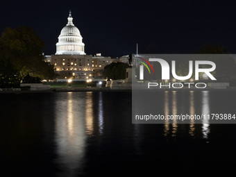 Night view with dark sky of the illuminated US Capitol reflecting on the pool water surface. The Capitol is the seat of the United States Co...