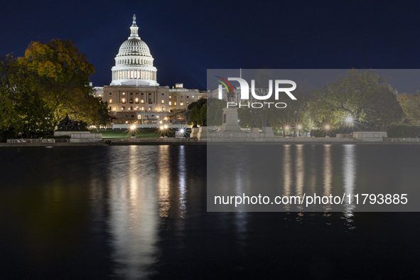 Night view with dark sky of the illuminated US Capitol reflecting on the pool water surface. The Capitol is the seat of the United States Co...