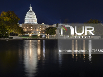 Night view with dark sky of the illuminated US Capitol reflecting on the pool water surface. The Capitol is the seat of the United States Co...