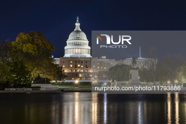 Night view with dark sky of the illuminated US Capitol reflecting on the pool water surface. The Capitol is the seat of the United States Co...