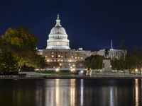 Night view with dark sky of the illuminated US Capitol reflecting on the pool water surface. The Capitol is the seat of the United States Co...