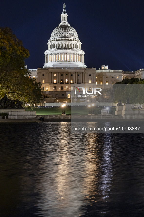 Night view with dark sky of the illuminated US Capitol reflecting on the pool water surface. The Capitol is the seat of the United States Co...