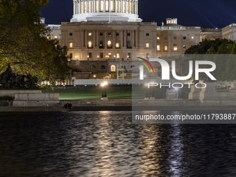 Night view with dark sky of the illuminated US Capitol reflecting on the pool water surface. The Capitol is the seat of the United States Co...