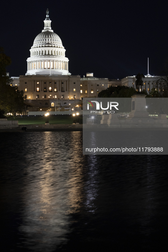 Night view with dark sky of the illuminated US Capitol reflecting on the pool water surface. The Capitol is the seat of the United States Co...