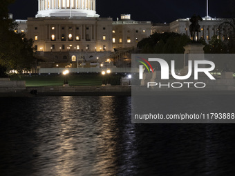 Night view with dark sky of the illuminated US Capitol reflecting on the pool water surface. The Capitol is the seat of the United States Co...