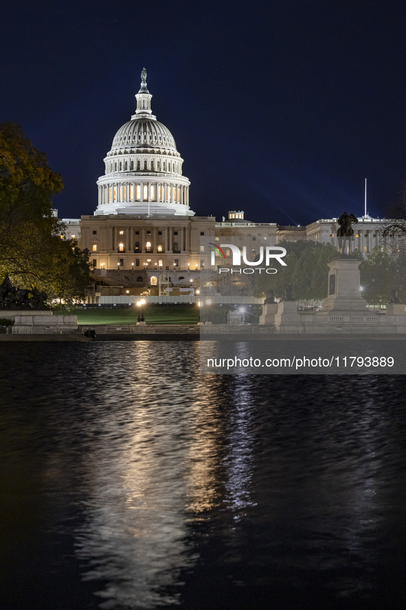 Night view with dark sky of the illuminated US Capitol reflecting on the pool water surface. The Capitol is the seat of the United States Co...