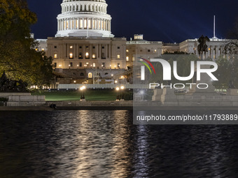 Night view with dark sky of the illuminated US Capitol reflecting on the pool water surface. The Capitol is the seat of the United States Co...