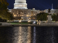 Night view with dark sky of the illuminated US Capitol reflecting on the pool water surface. The Capitol is the seat of the United States Co...