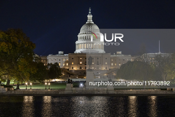 Night view with dark sky of the illuminated US Capitol reflecting on the pool water surface. The Capitol is the seat of the United States Co...