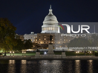 Night view with dark sky of the illuminated US Capitol reflecting on the pool water surface. The Capitol is the seat of the United States Co...