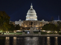 Night view with dark sky of the illuminated US Capitol reflecting on the pool water surface. The Capitol is the seat of the United States Co...