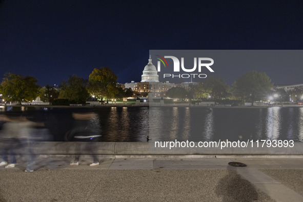 Night view with dark sky of the illuminated US Capitol reflecting on the pool water surface. The Capitol is the seat of the United States Co...