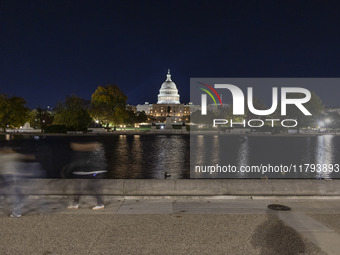 Night view with dark sky of the illuminated US Capitol reflecting on the pool water surface. The Capitol is the seat of the United States Co...