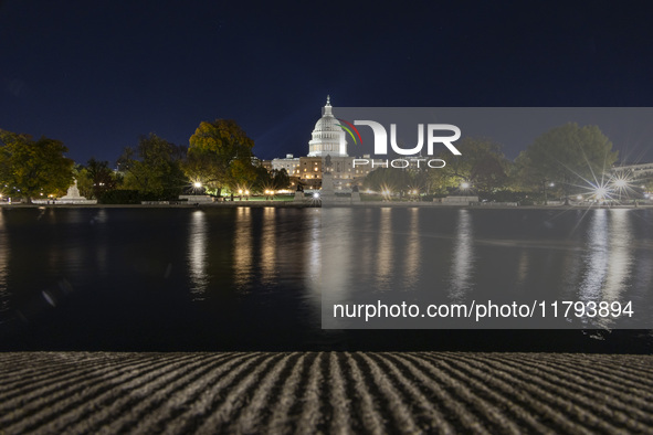 Night view with dark sky of the illuminated US Capitol reflecting on the pool water surface. The Capitol is the seat of the United States Co...