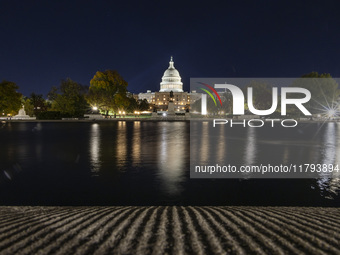 Night view with dark sky of the illuminated US Capitol reflecting on the pool water surface. The Capitol is the seat of the United States Co...