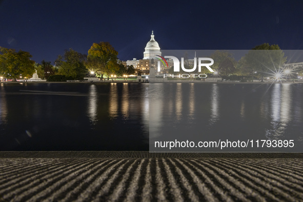 Night view with dark sky of the illuminated US Capitol reflecting on the pool water surface. The Capitol is the seat of the United States Co...