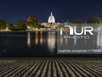 Night view with dark sky of the illuminated US Capitol reflecting on the pool water surface. The Capitol is the seat of the United States Co...