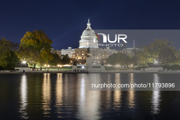 Night view with dark sky of the illuminated US Capitol reflecting on the pool water surface. The Capitol is the seat of the United States Co...