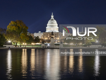 Night view with dark sky of the illuminated US Capitol reflecting on the pool water surface. The Capitol is the seat of the United States Co...