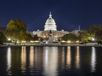 Night view with dark sky of the illuminated US Capitol reflecting on the pool water surface. The Capitol is the seat of the United States Co...