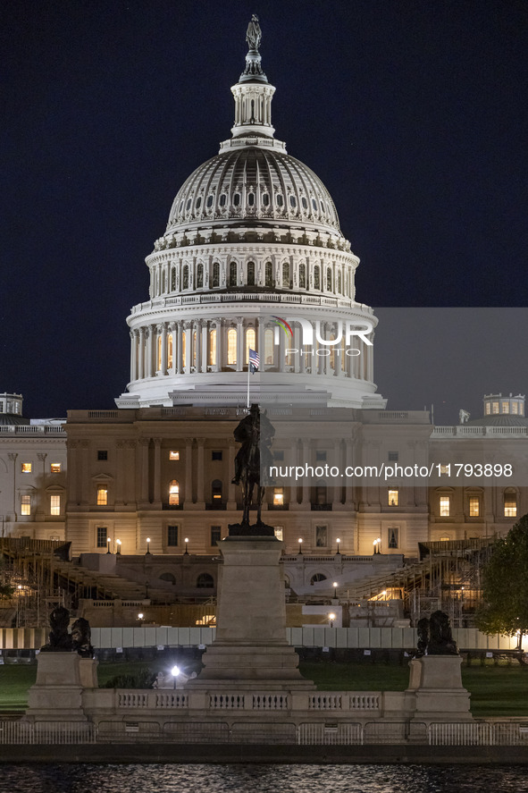 Night view with dark sky of the illuminated US Capitol reflecting on the pool water surface. The Capitol is the seat of the United States Co...