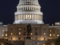 Night view with dark sky of the illuminated US Capitol reflecting on the pool water surface. The Capitol is the seat of the United States Co...