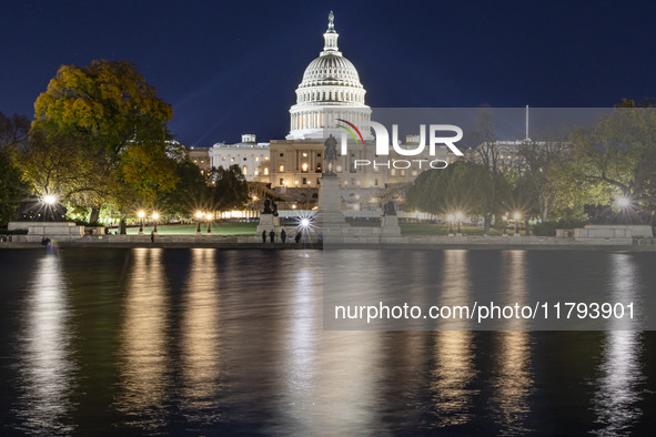 Night view with dark sky of the illuminated US Capitol reflecting on the pool water surface. The Capitol is the seat of the United States Co...