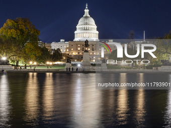 Night view with dark sky of the illuminated US Capitol reflecting on the pool water surface. The Capitol is the seat of the United States Co...