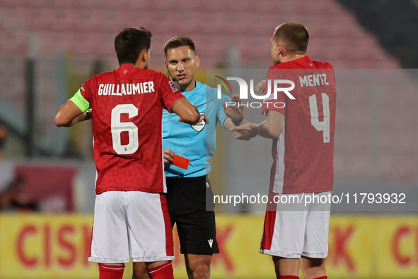 In Ta' Qali, Malta, on November 19, 2024, UEFA appoints match referee Luka Bilbija (center) to speak to Matthew Guillaumier of Malta during...