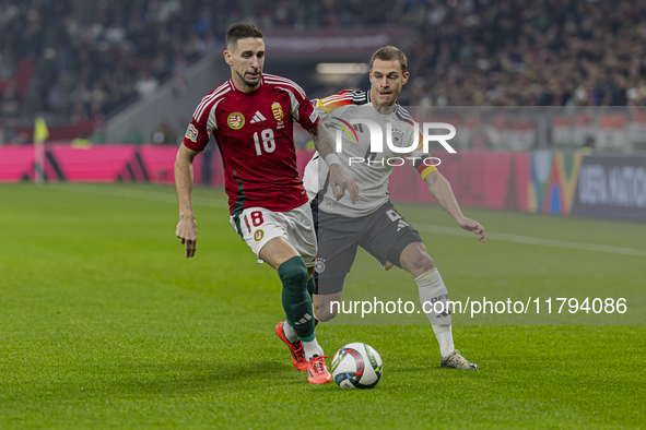 Zsolt Nagy of Hungary competes for the ball with Joshua Kimmich of Germany during the UEFA Nations League Group match at Puskas Arena in Bud...