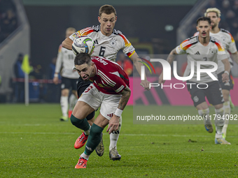 Zsolt Nagy of Hungary competes for the ball with Joshua Kimmich of Germany during the UEFA Nations League Group match at Puskas Arena in Bud...