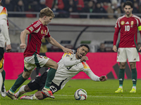 Andras Schafer of Hungary competes for the ball with Benjamin Henrichs of Germany during the UEFA Nations League Group match at Puskas Arena...