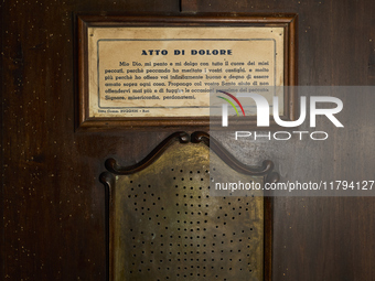 This image shows the exterior of a confessional in the crypt of the San Sabino Cathedral in Bari, Italy. A sign displays the ''Atto di Dolor...