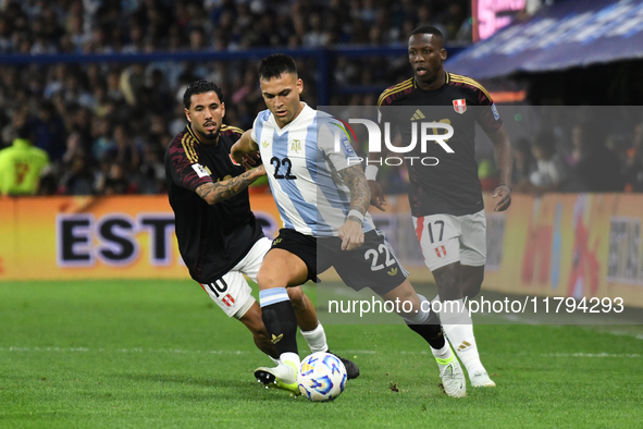 Lautaro Martinez of Argentina plays the ball with Sergio Pena and Luis Advincula of Peru during the match between Argentina and Peru at Albe...