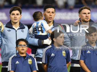 Julian Alvarez, Enzo Fernandez, and Alexis Mac Allister of Argentina stand during the national anthems ceremony before the match between Arg...