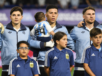 Julian Alvarez, Enzo Fernandez, and Alexis Mac Allister of Argentina stand during the national anthems ceremony before the match between Arg...