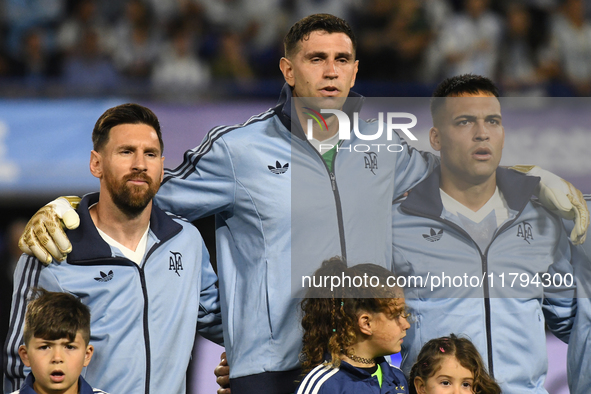 Lionel Messi, Emiliano Martinez, and Lautaro Martinez of Argentina stand during the national anthems ceremony before the match between Argen...