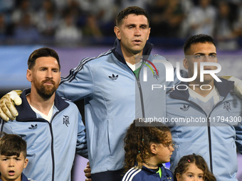 Lionel Messi, Emiliano Martinez, and Lautaro Martinez of Argentina stand during the national anthems ceremony before the match between Argen...