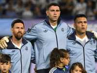 Lionel Messi, Emiliano Martinez, and Lautaro Martinez of Argentina stand during the national anthems ceremony before the match between Argen...