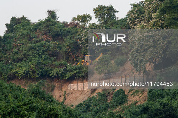 A vehicle approaches as the wall marking the border between India and Bangladesh is visible in Durgapur, Netrokona, Bangladesh, on November...