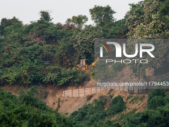 A vehicle approaches as the wall marking the border between India and Bangladesh is visible in Durgapur, Netrokona, Bangladesh, on November...