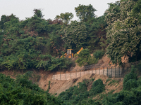 A vehicle approaches as the wall marking the border between India and Bangladesh is visible in Durgapur, Netrokona, Bangladesh, on November...