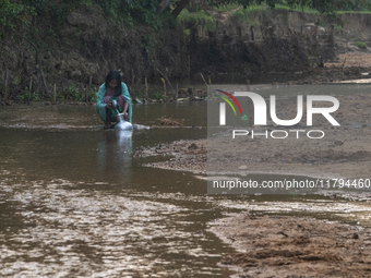 A local girl collects water from the reservoir locally called ''Jhiri'' in Durgapur, Netrokona, Bangladesh, on November 17, 2024. The reserv...