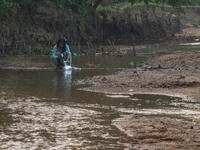 A local girl collects water from the reservoir locally called ''Jhiri'' in Durgapur, Netrokona, Bangladesh, on November 17, 2024. The reserv...