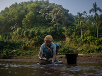 A tribal woman cleans vegetables at a reservoir, locally known as ''Jhiri,'' in Durgapur, Netrokona, Bangladesh, on November 17, 2024. The r...