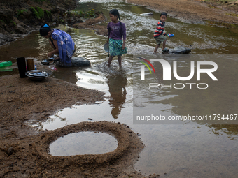 A family comes to the reservoir for their daily activities, such as cleaning dishes, brushing teeth, and bathing, in Durgapur, Netrokona, Ba...