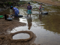 A family comes to the reservoir for their daily activities, such as cleaning dishes, brushing teeth, and bathing, in Durgapur, Netrokona, Ba...