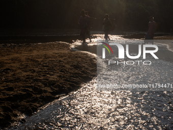 Local people walk past the reservoir in Durgapur, Netrokona, Bangladesh, on November 17, 2024. The reservoir, known as ''Jhiri,'' serves as...