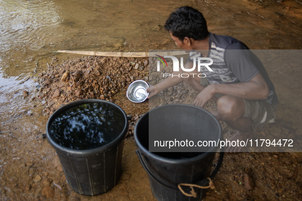 A tribal man collects water from the reservoir, locally known as ''Jhiri,'' in Durgapur, Netrokona, Bangladesh, on November 17, 2024. The re...