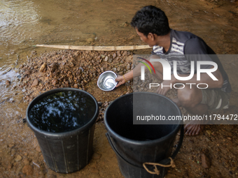 A tribal man collects water from the reservoir, locally known as ''Jhiri,'' in Durgapur, Netrokona, Bangladesh, on November 17, 2024. The re...